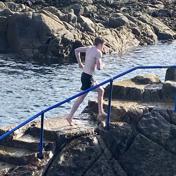 Young man running out of the sea